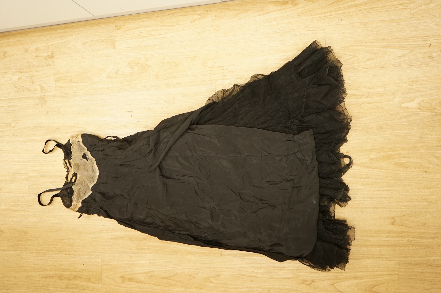 A late 1940’s black lace evening dress, a similar evening dress with black velvet ribbon detail, a maroon brocade halter neck evening dress and a dark mustard early 1950’s evening silk duster coat.